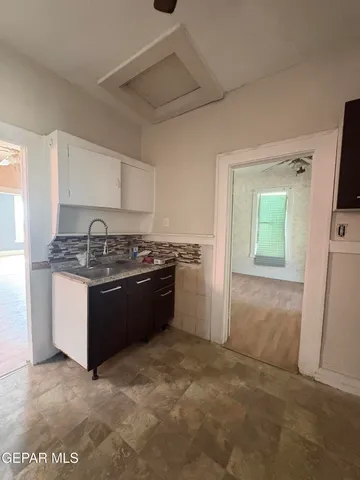a kitchen with a refrigerator and a stove top oven