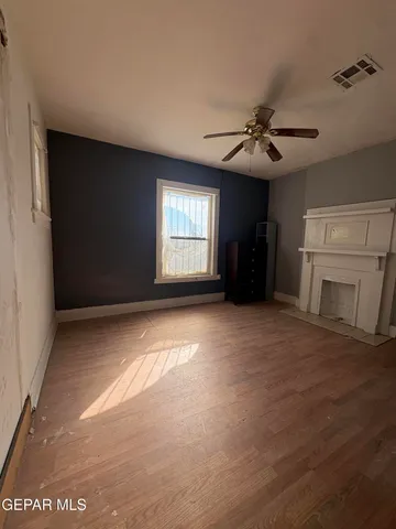 a view of an empty room with a fireplace and a window