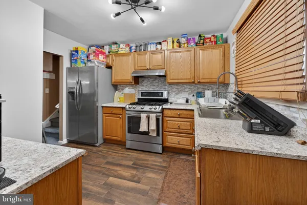 a kitchen with granite countertop a sink stove and refrigerator