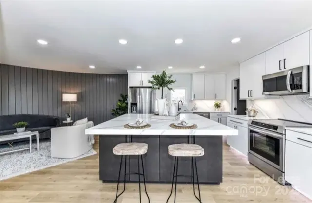 a kitchen with a dining table chairs and stainless steel appliances