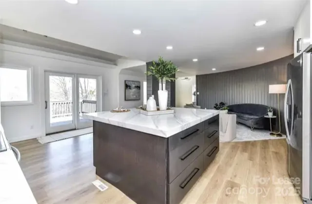 a large kitchen with stainless steel appliances granite countertop a large counter top a stove and a refrigerator