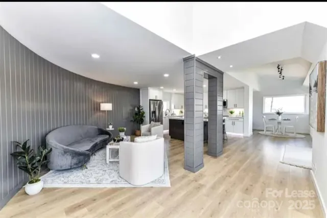 a living room with furniture and a wooden floor