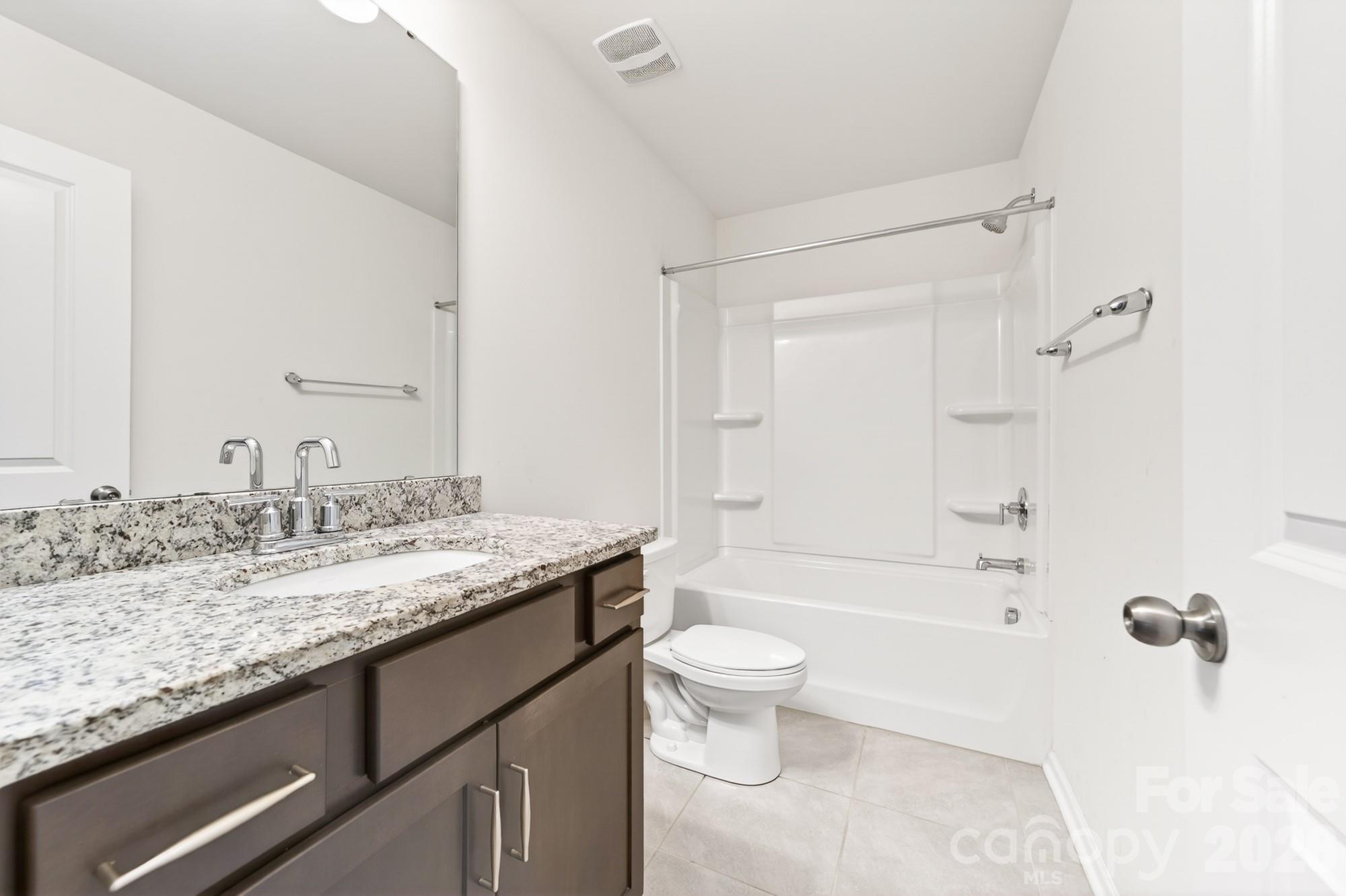 5972 Redwood Pine Road Concord, NC 28027 - Photo 29 of 37 a bathroom with a granite countertop sink a toilet and bathtub