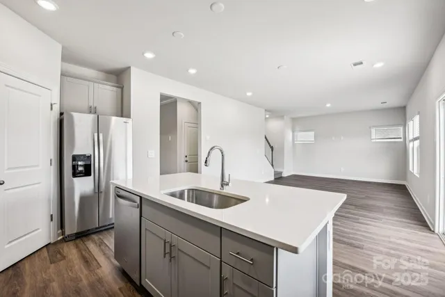a kitchen with stainless steel appliances a sink and a refrigerator