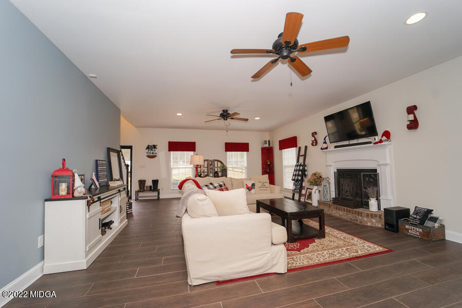 5281 Purple Road Byron, GA 31008 - Photo 15 of 42 a living room with furniture a fireplace and a flat screen tv