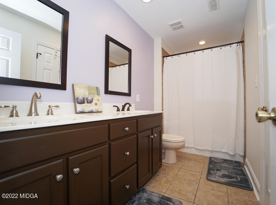 5281 Purple Road Byron, GA 31008 - Photo 34 of 42 a bathroom with a double vanity sink toilet and mirror