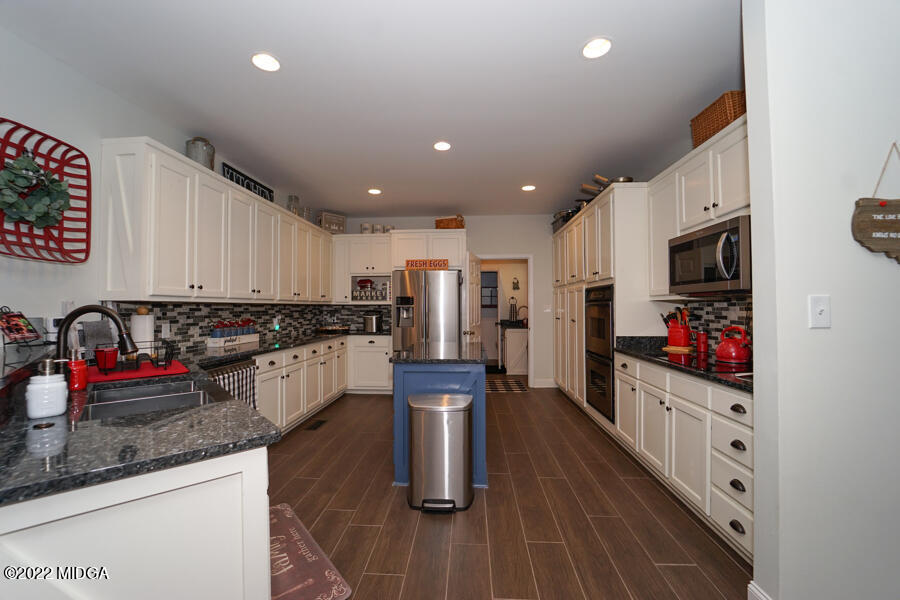 5281 Purple Road Byron, GA 31008 - Photo 7 of 42 a kitchen with stainless steel appliances kitchen island granite countertop a refrigerator a stove and a wooden floors