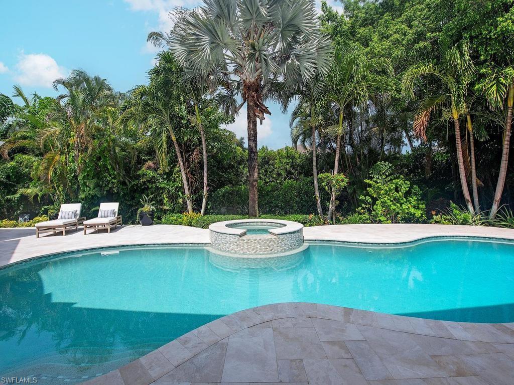 2363 Crayton Road Naples, FL 34103 - Photo 4 of 30 Freeform swimming pool with an integrated circular spa featuring mosaic tile detailing