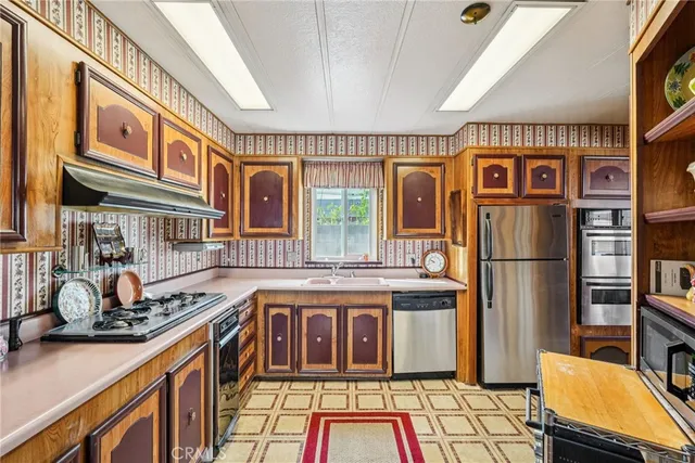 a view of a kitchen with stainless steel appliances granite countertop a stove and a sink