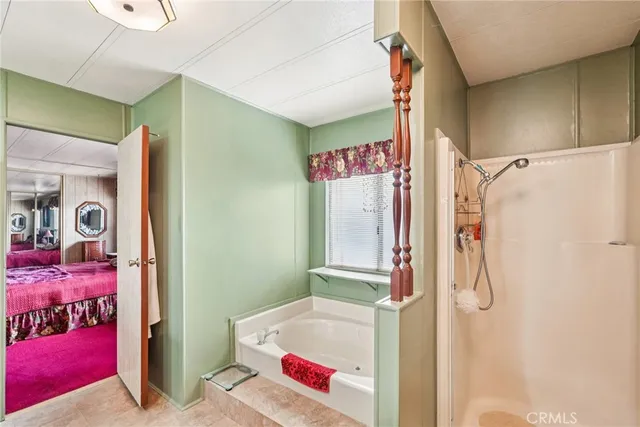 a bedroom with a bed and dresser with mirror