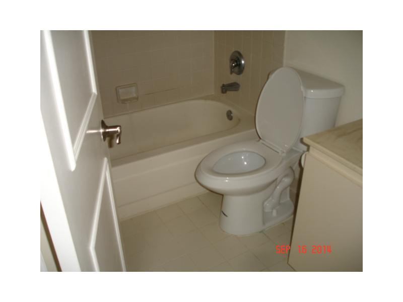 9033 Wiles Road, Unit 1084 Coral Springs, FL 33067 - Photo 4 of 12 a bathroom with a toilet and a shower