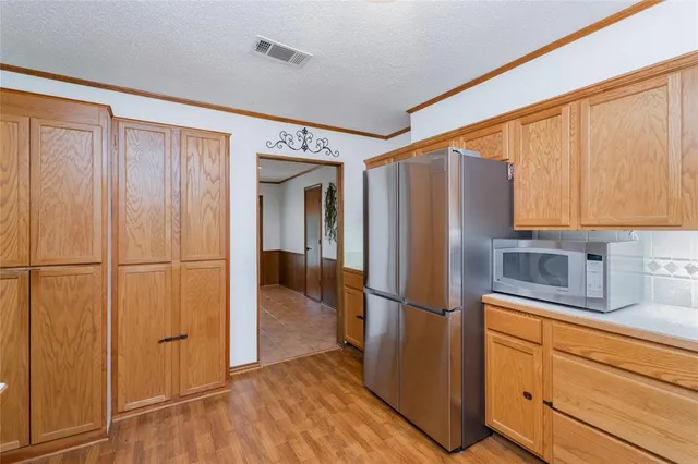 a kitchen with stainless steel appliances granite countertop a refrigerator and a stove top oven