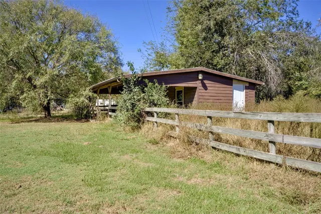 a view of a swimming pool with a yard and a large tree