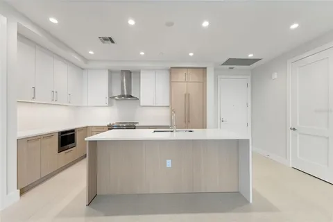a kitchen with kitchen island sink stove and cabinets