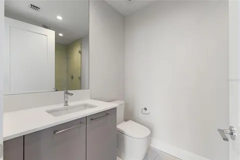 a bathroom with a sink a toilet and mirror