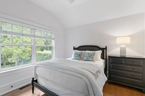 a bedroom with a bed and a large window