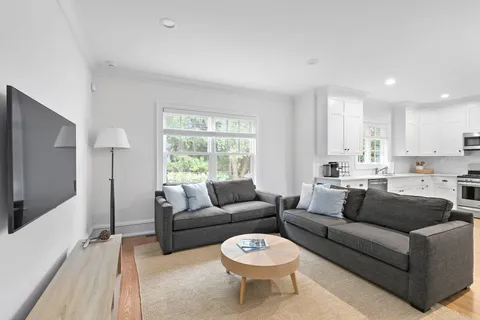 a living room with furniture a large window and a flat screen tv