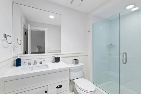 a bathroom with a sink toilet a mirror and shower