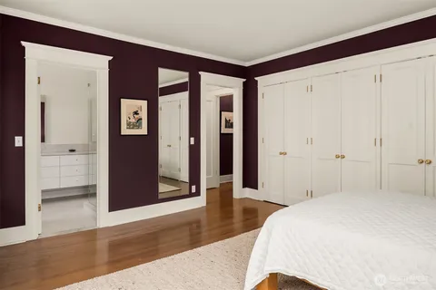 a spacious bedroom with a bed and wooden floor