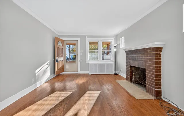 a view of a livingroom with wooden floor and a fireplace