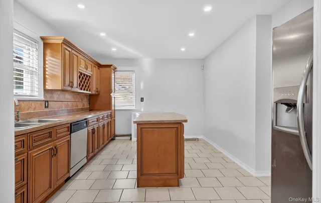 a kitchen with stainless steel appliances granite countertop a refrigerator and a sink