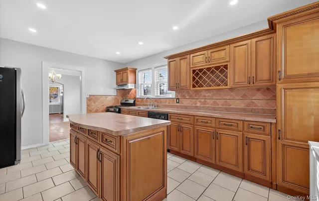 a kitchen with stainless steel appliances granite countertop a sink and a refrigerator