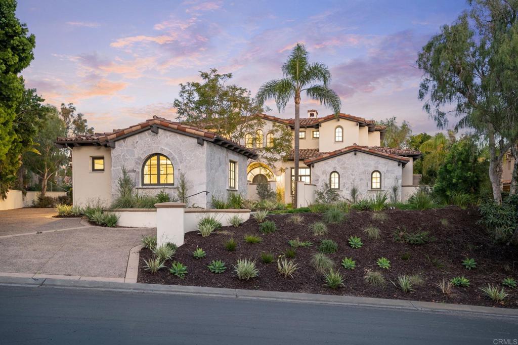 a front view of a house with a yard and potted plants