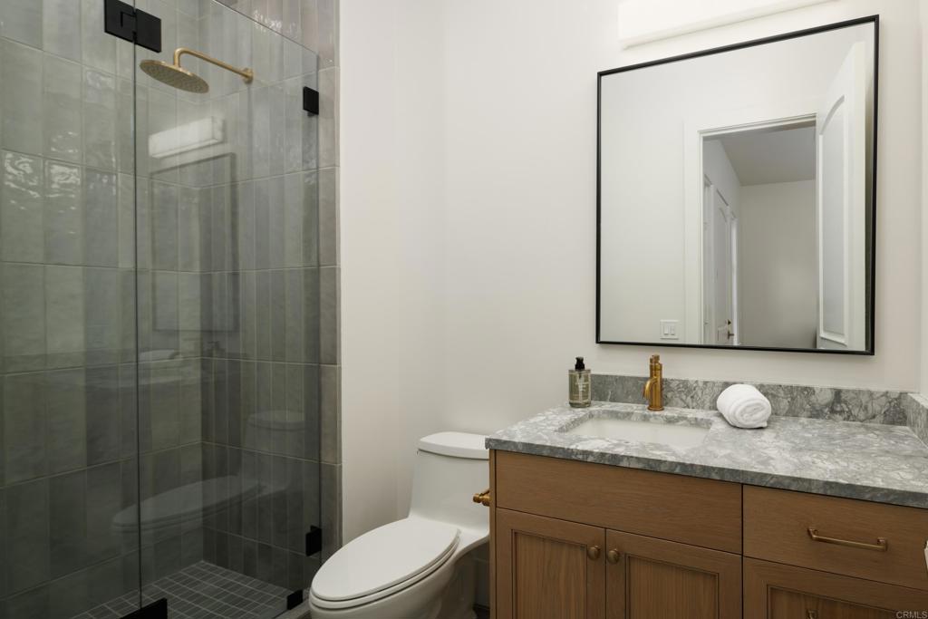 5146 Rancho Verde Trail San Diego, CA 92130 - Photo 29 of 34 a bathroom with a granite countertop sink toilet and shower
