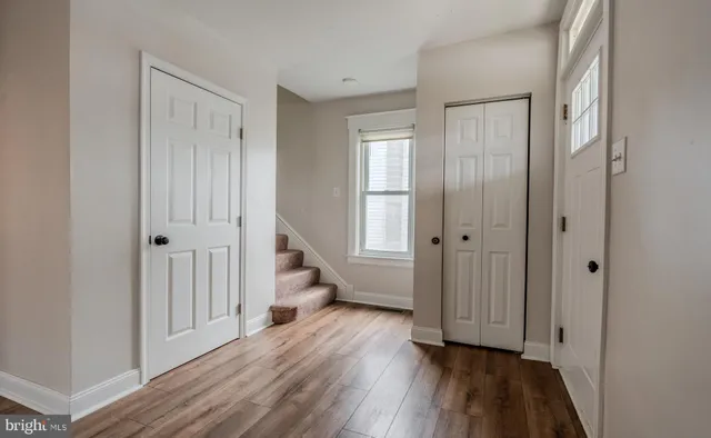 a view of a hallway with wooden floor and closet area
