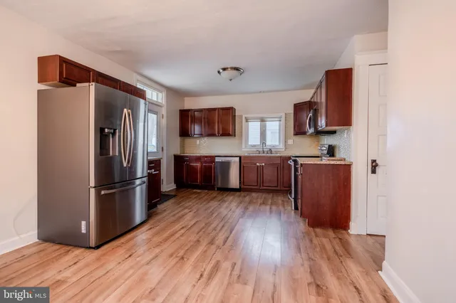 a kitchen with stainless steel appliances granite countertop a refrigerator microwave and sink