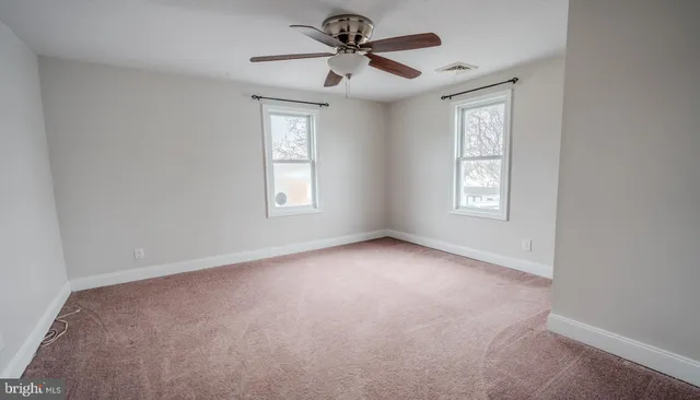 a view of a room with windows and a ceiling fan
