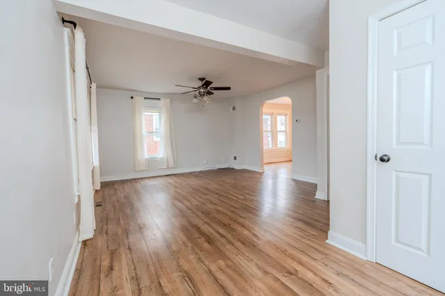 a view of empty room with window and wooden floor