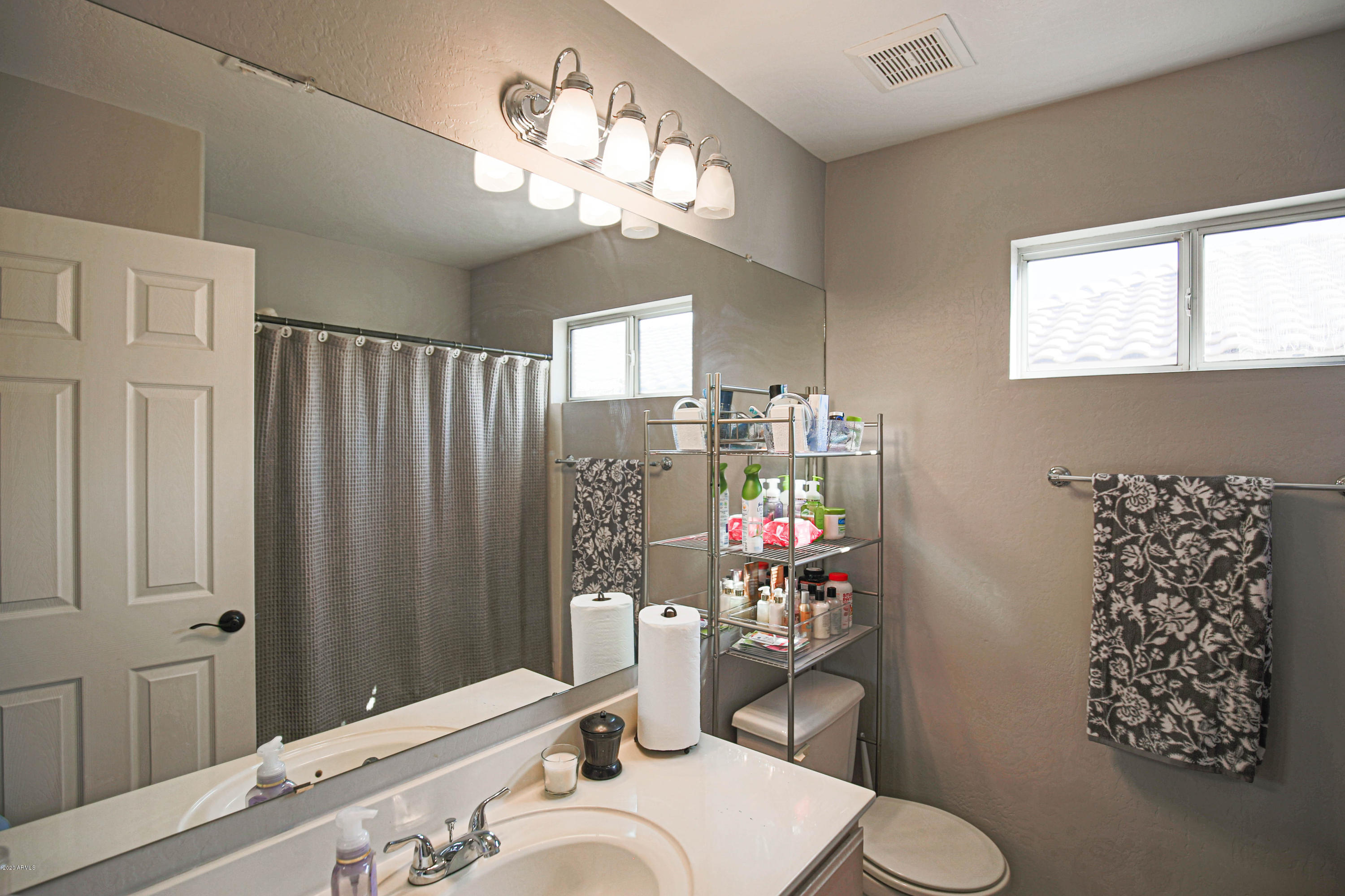 16666 South 21st Street Phoenix, AZ 85048 - Photo 30 of 43 a bathroom with a sink a toilet a mirror and shower curtain