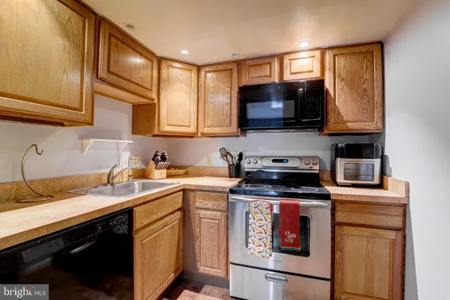 a kitchen with stainless steel appliances granite countertop a sink a stove and a microwave