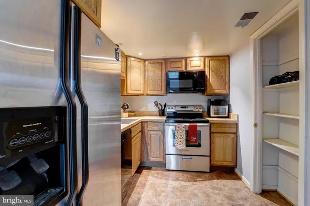 a kitchen with stainless steel appliances granite countertop a refrigerator stove and sink