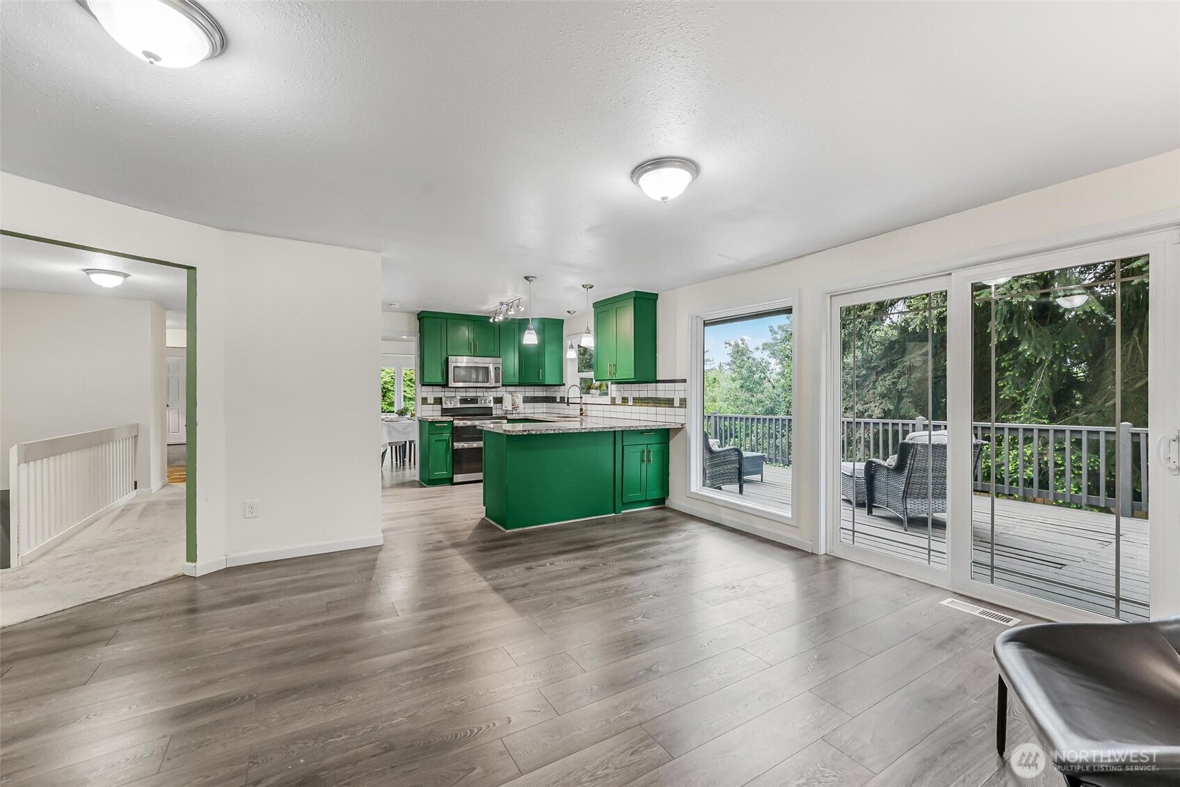 11404 Karshner Road East Edgewood, WA 98372 - Photo 16 of 40 a room with kitchen island a large window and a wooden floor