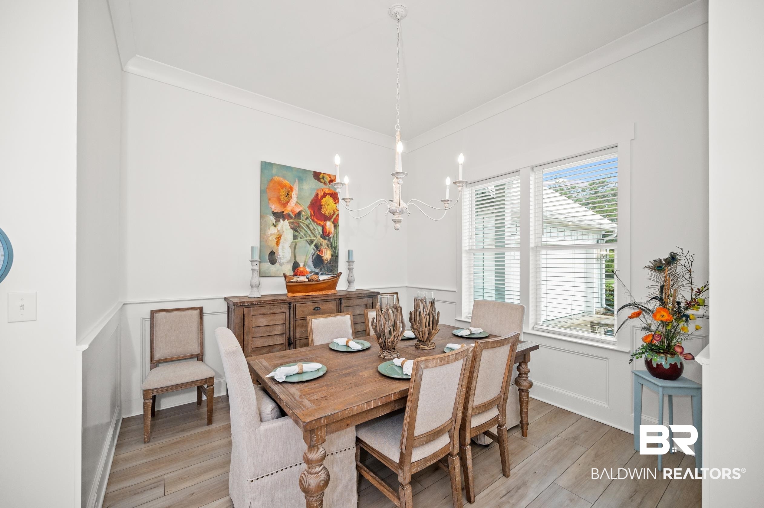 4601 Surrey Lane Orange Beach, AL 36561 - Photo 6 of 43 Dining space featuring light wood-type flooring, a chandelier, and crown molding