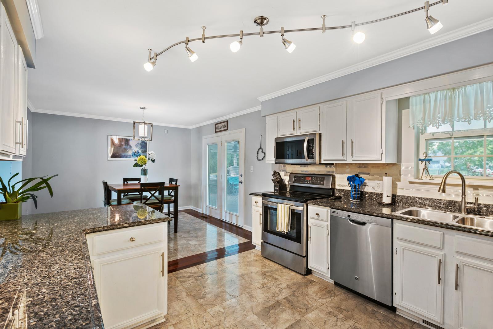 682 Baker Road Columbia, TN 38401 - Photo 13 of 30 a kitchen with granite countertop white cabinets and white appliances