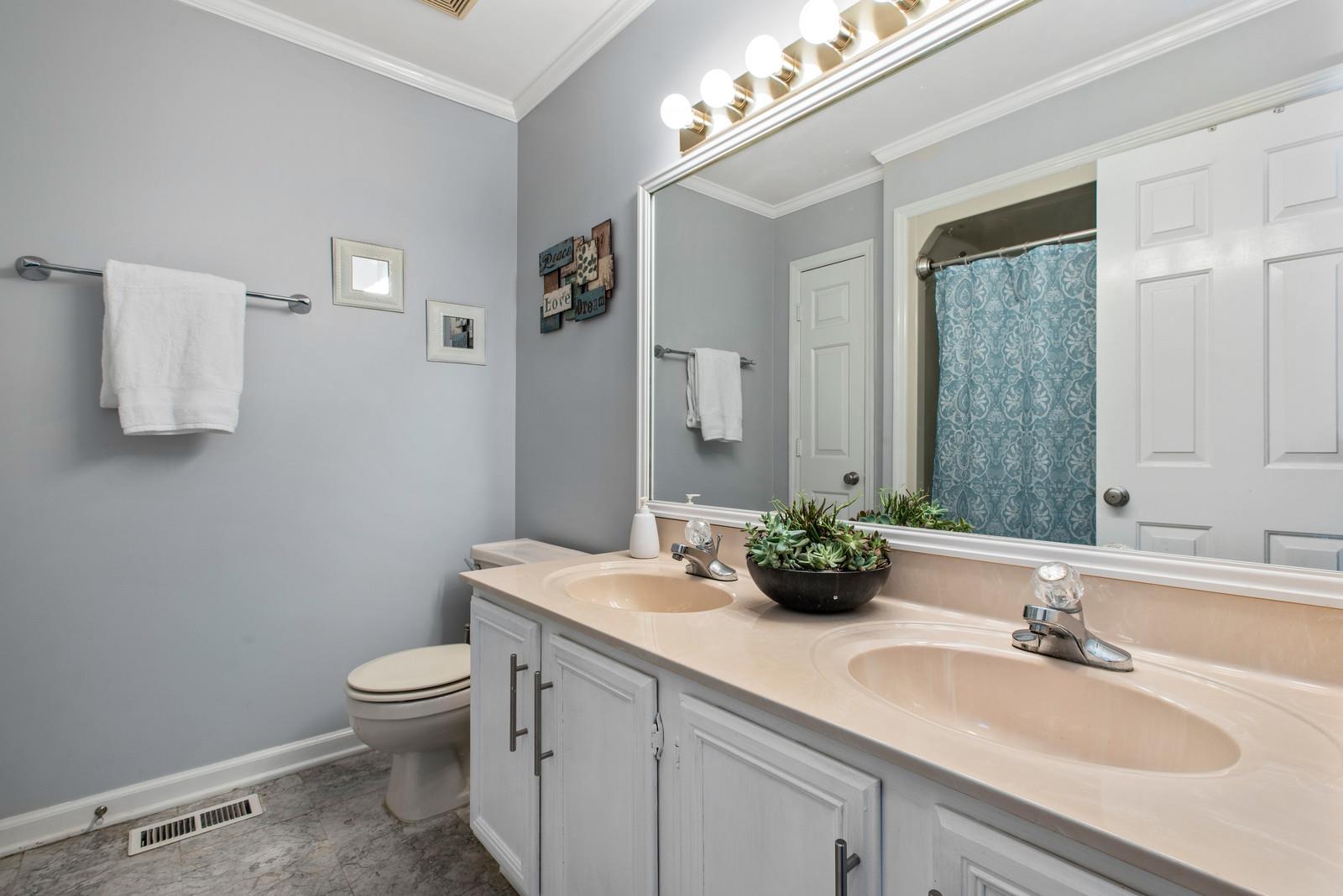 682 Baker Road Columbia, TN 38401 - Photo 21 of 30 a bathroom with a double vanity sink toilet and a mirror