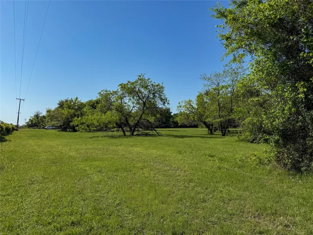 a view of a field of grass and trees
