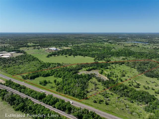 an aerial view of residential houses with outdoor space and trees