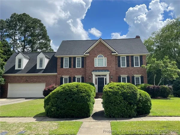 a view of a white house with a big yard and potted plants