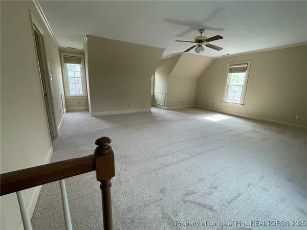 en empty room with windows and ceiling fan