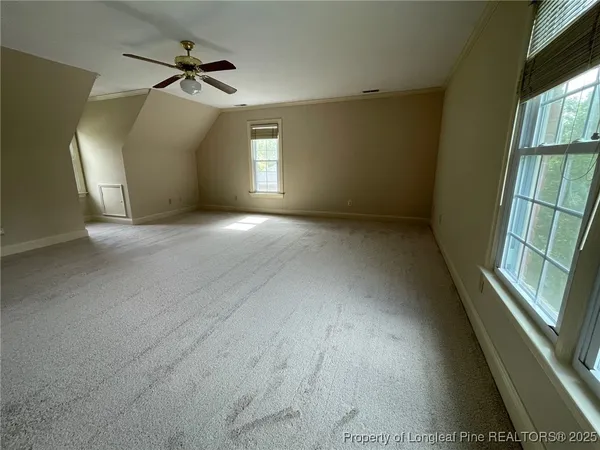 a view of a big room with windows and chandelier fan