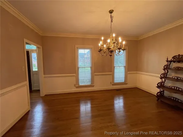 a view of a room with wooden floor and chandelier
