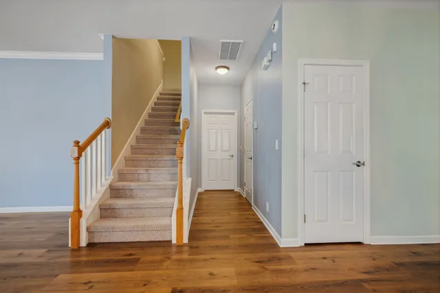 a view of a hallway with wooden floor and entryway