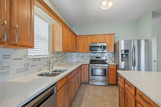 a kitchen with stainless steel appliances granite countertop a sink stove and refrigerator