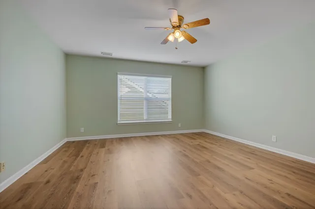 an empty room with a window and wooden floor