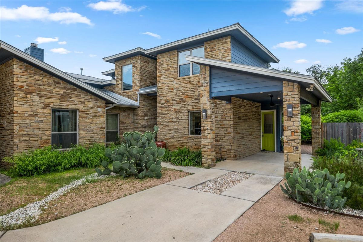 913 Stobaugh Street, Unit B Austin, TX 78757 - Photo 1 of 40 Crafted with stacked stone and striking blue siding, this residence features a welcoming covered entry and verdant desert landscaping.