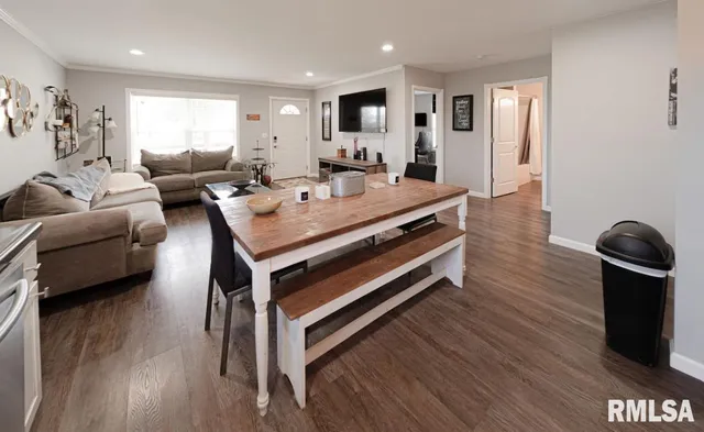 a living room with furniture a wooden floor and potted plant